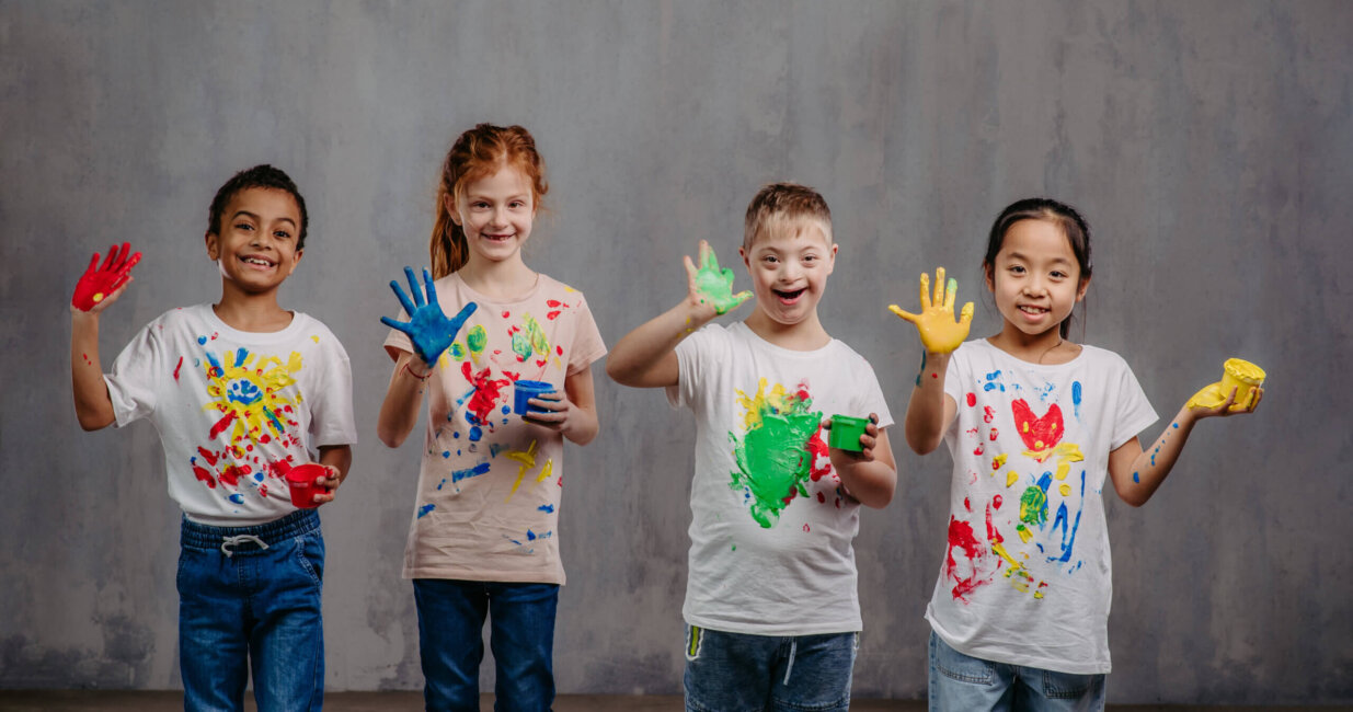 four school aged children with multicolor finger paint.