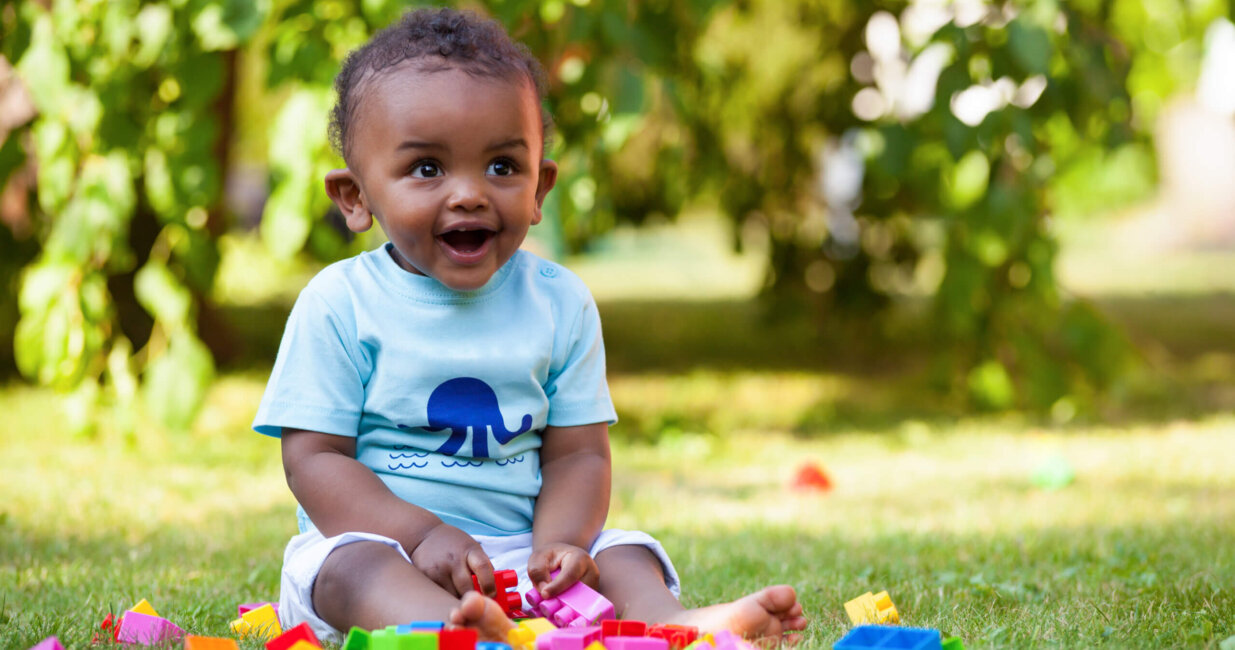 Child in park playing with colorful blocks.